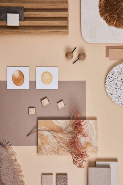 Flat lay of stylish architect moodboard composition with beige samples of textile, paint, wooden lamella panels and tiles. Top view. Copy space. Template.